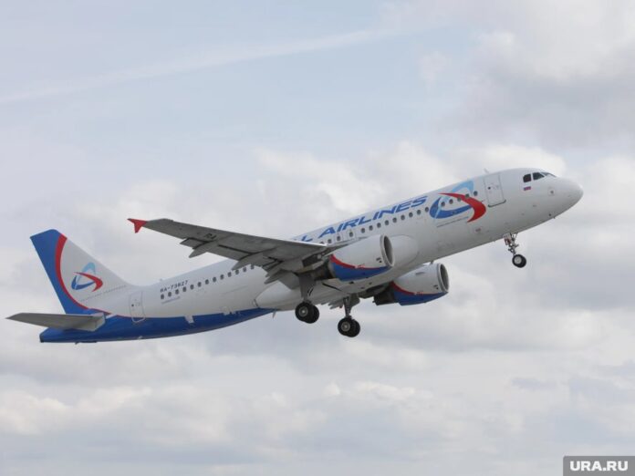 Пассажиры на фоне самолета Уральских авиалиний, готовящегося к вылету в ОАЭ, на фоне сугробов