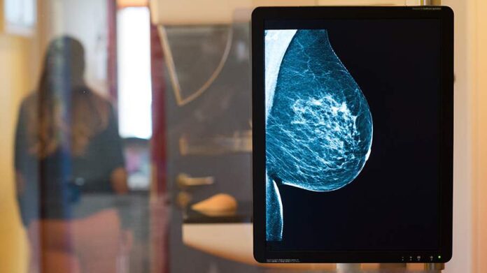 Женщина пьет кофе утром, задумчиво глядя в окно, перед выбором нижнего белья.