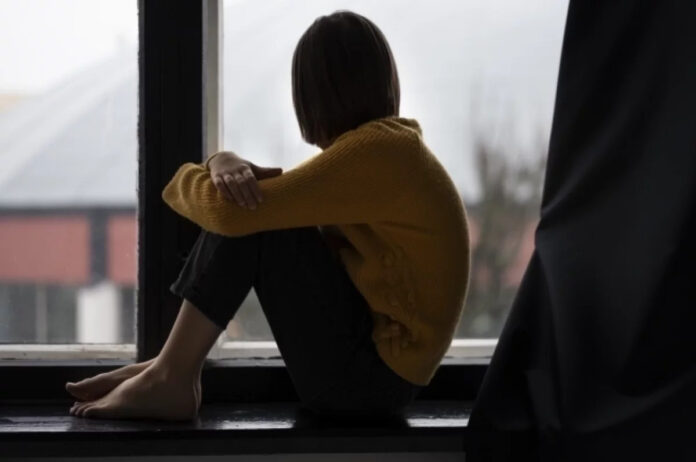 Человек держит в руке выключенный пульт от телевизора, смотрящий на него как на решение проблем