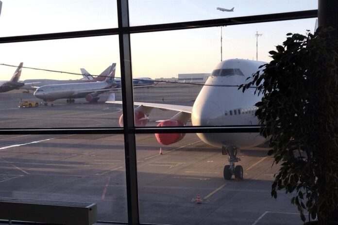 Молодая студентка МГУ с рюкзаком, на фоне аэропорта или поезда, символизирующая путешествие из Перми в Москву на учебу