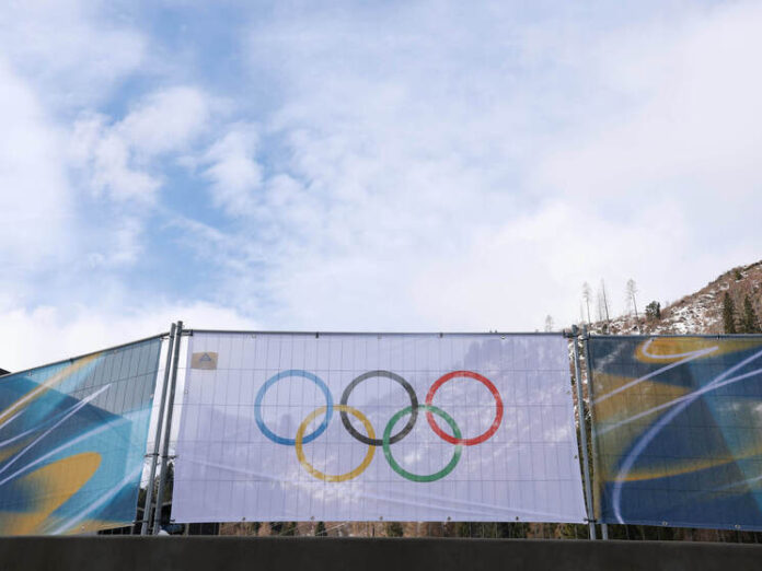 Фигуристка Алёна Крылова исполняет произвольную программу на льду, демонстрируя сложный элемент.