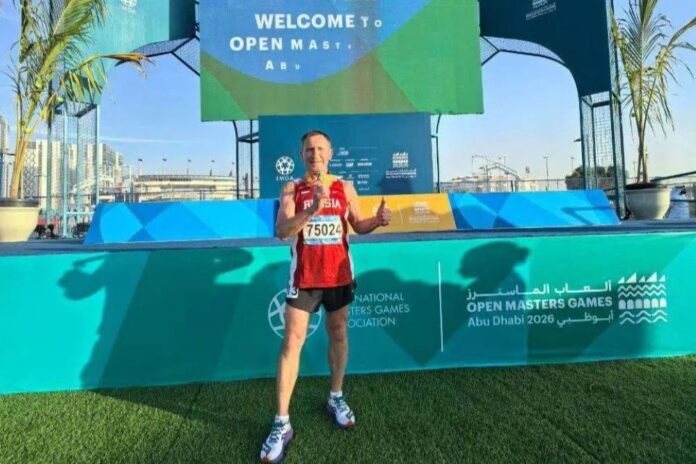 Спортсмен из Бурятии празднует победу на фоне пустынного пейзажа Абу-Даби