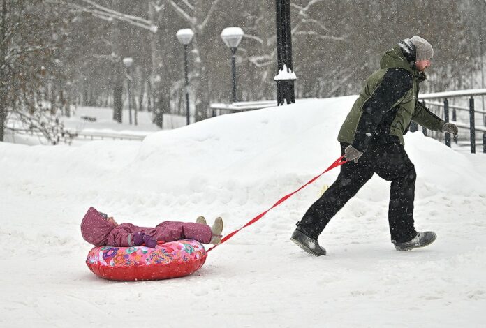 Молодая семья на фоне дома с голубем и символом скидки на электричество