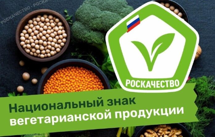 Бутылка веганского алкоголя рядом с зелеными листьями, символизирующими растительное происхождение.