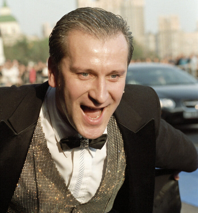 Сергей Пенкин в ярком сценическом костюме, держащий микрофон