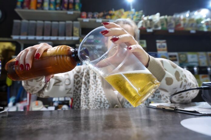 Бутылка русской водки на фоне заснеженного пейзажа с силуэтом совы