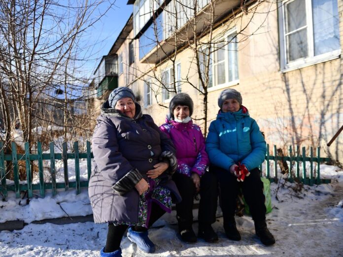 Иллюстрация, изображающая пожилую женщину, окруженную символами здоровья и долголетия, с элементами науки и природы.