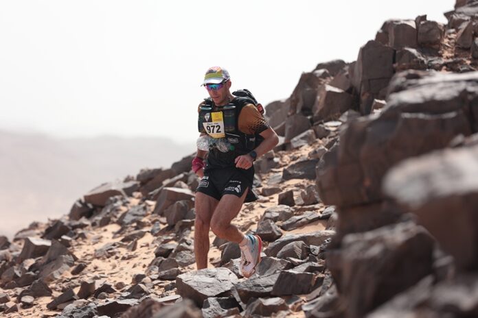 91-летний мужчина в спортивной одежде бежит марафон, улыбается, у него седая борода.