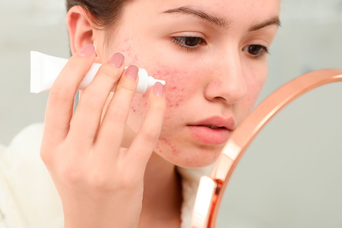 Девушка наносит крем