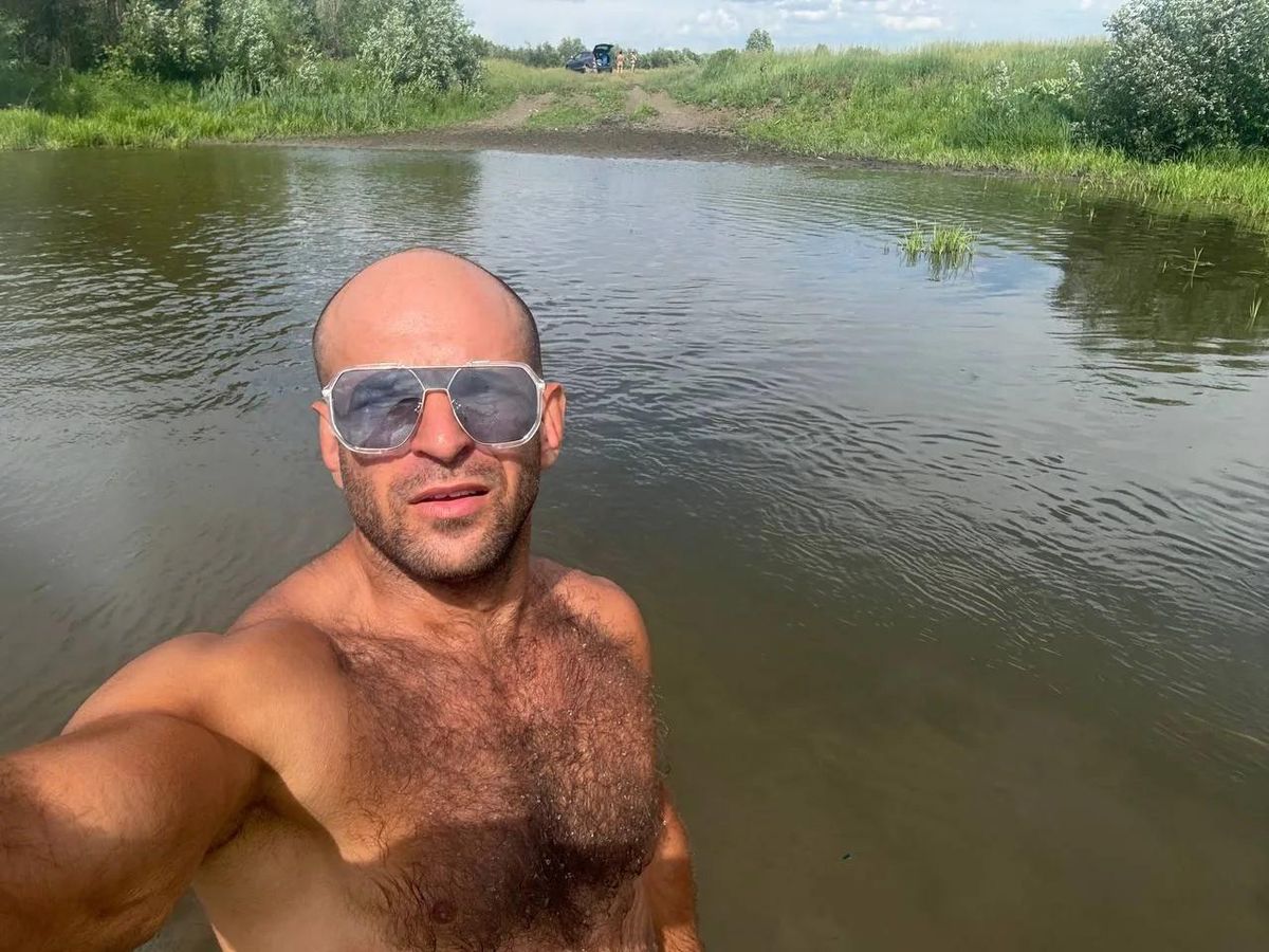 Агроном из Сибири, стоящий на фоне полей с урожаем