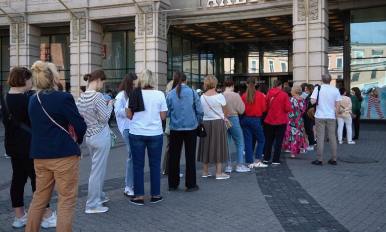 Молодые люди выбирают винтажные вещи в бутике