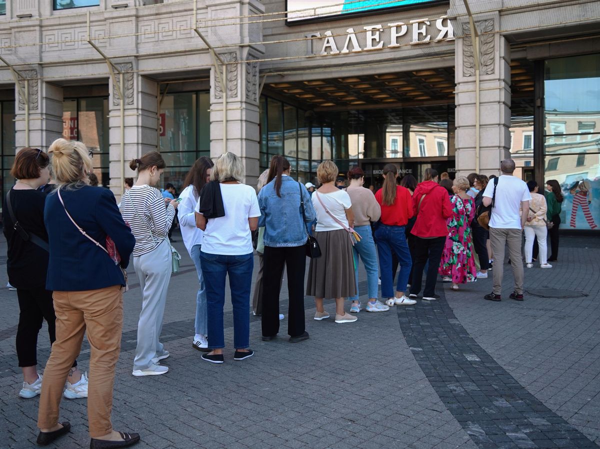 Молодые люди выбирают винтажные вещи в бутике