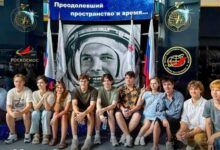 Российские школьники с кубком в руках на фоне модели города в поясе астероидов