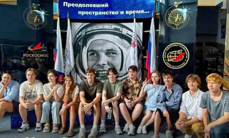 Российские школьники с кубком в руках на фоне модели города в поясе астероидов