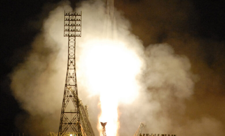Космонавт на фоне ракеты Dragon, готовящейся к запуску с мыса Канаверал