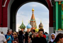 Туристы рассматривают матрешки на фоне северного сияния