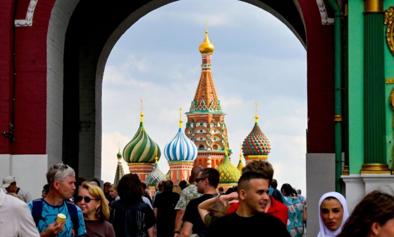 Туристы рассматривают матрешки на фоне северного сияния