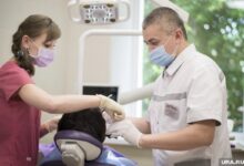 Стоматолог, улыбающийся во время лечения пациента